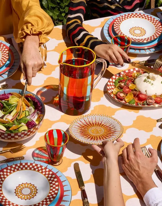 Colorful alfresco table setting with striped glass pitcher and checkered plates