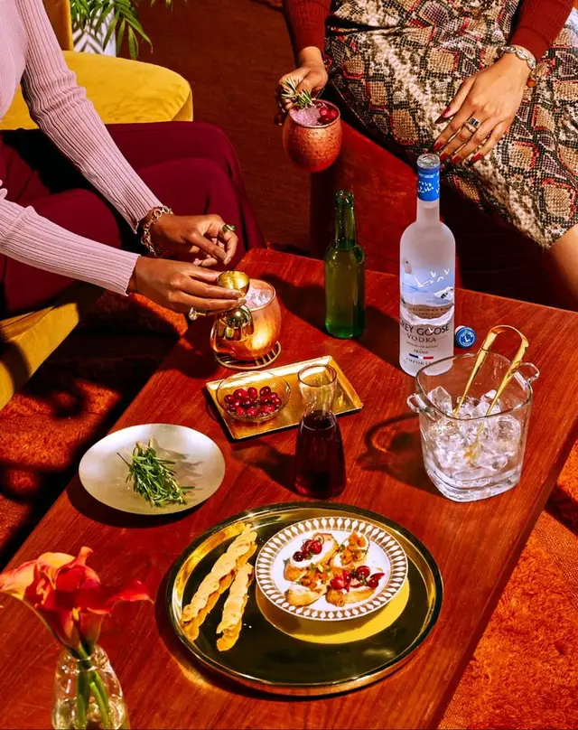 Warm mid-century cocktail spread with Grey Goose bottle