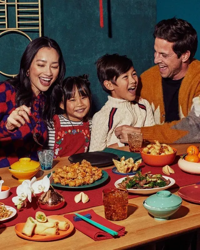 Family dinner with spring rolls, fortune cookies and mandarins