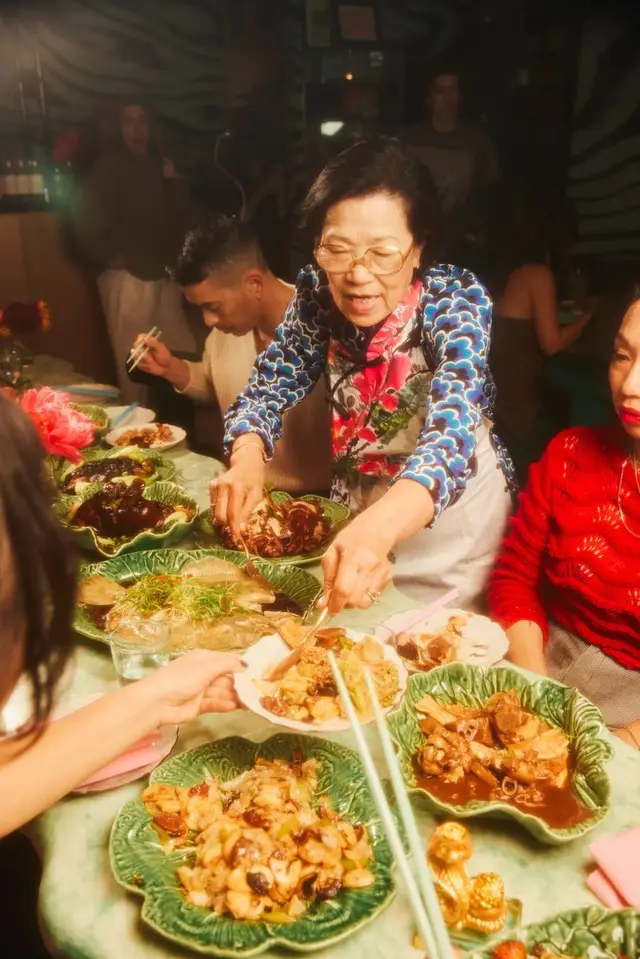 Elderly woman serving from green cabbage-shaped ceramic bowls at family banquet