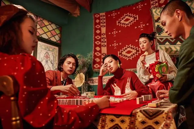 Mahjong night on a red felt table with kilim tapestry backdrop