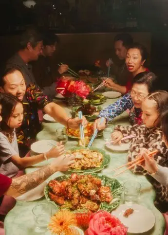 Multigenerational family-style dinner with chopsticks and green ceramic platters