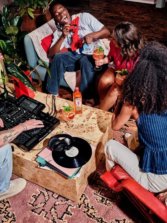 Living-room house party with DJ controller, vinyl records and cocktails
