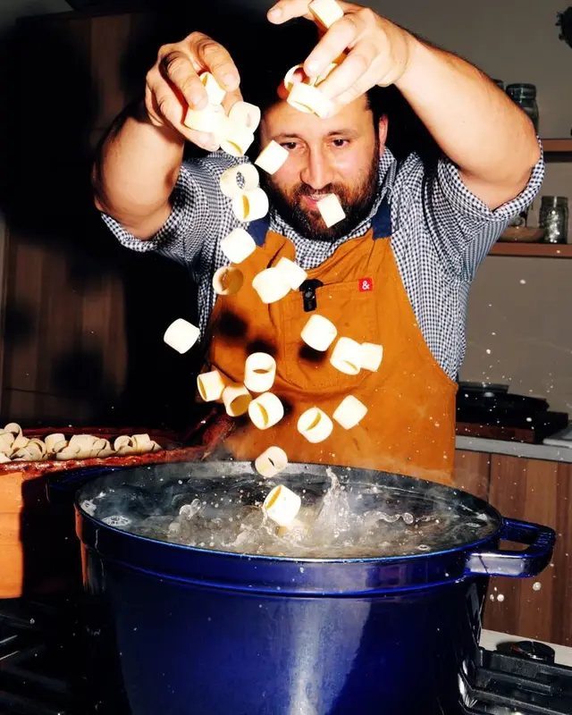 Tossing mini marshmallows into a steaming blue pot