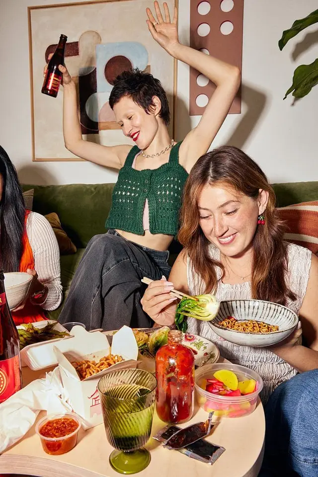 Living-room noodle night — friends, takeout, and drinks