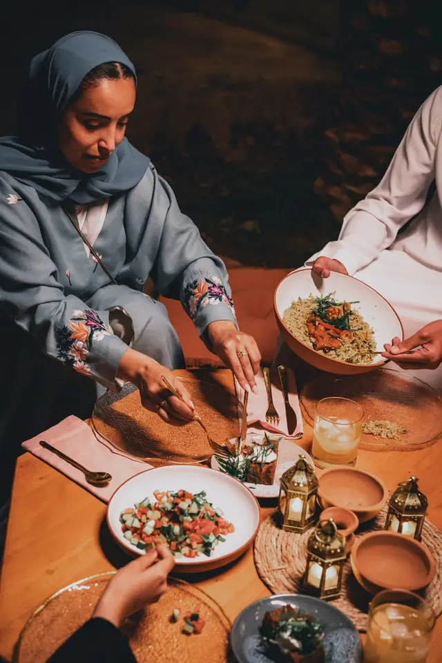 Iftar-style family meal with brass lanterns and embroidered abaya