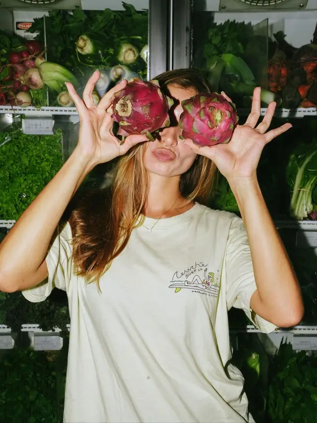 Playful portrait with dragon fruits in supermarket produce fridge