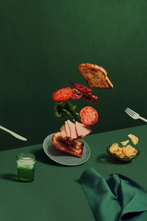 Levitating BLT-style Sandwich on Deep Green Table