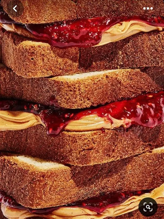 Stacked peanut butter and berry jam sandwiches — close-up