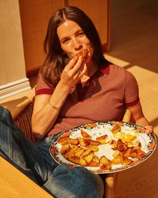 Casual lifestyle photo: eating roasted potato wedges from floral ceramic plate