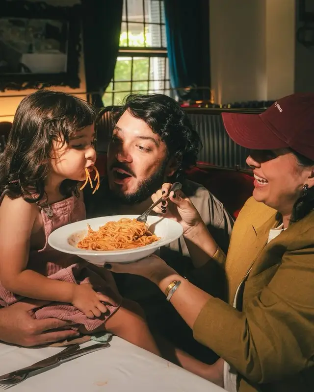 Family sharing spaghetti in a cozy restaurant booth