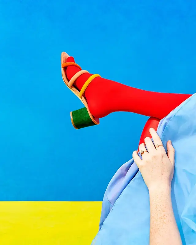 Red tights with green block-heel sandal — color-block fashion editorial