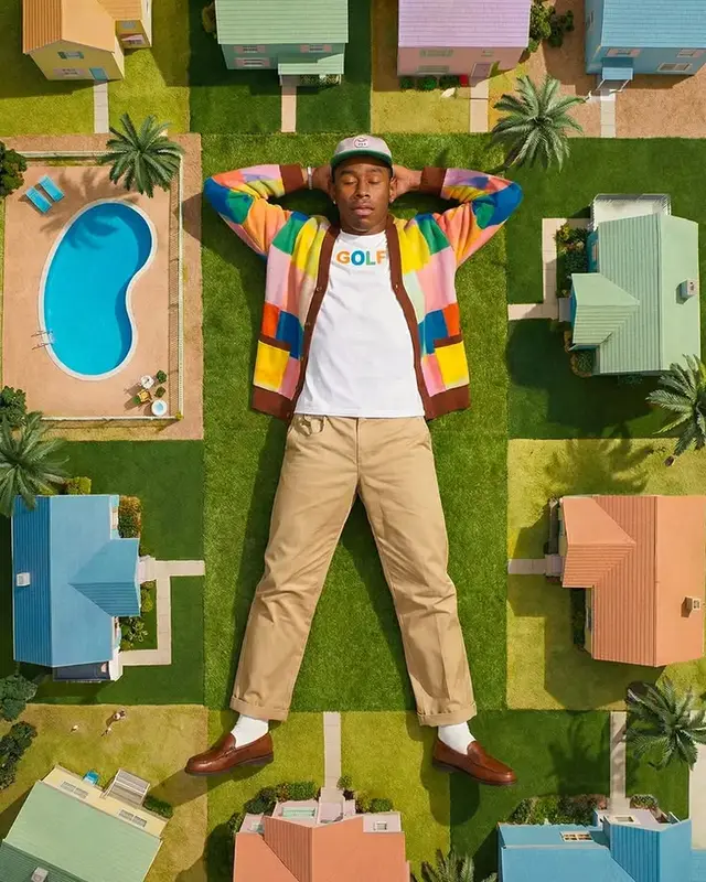 Overhead fashion shot — man in 'GOLF' tee on miniature pastel suburb