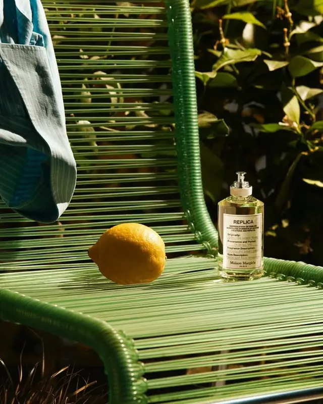 Maison Margiela Replica fragrance and lemon on green woven chair