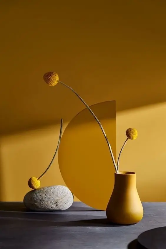 Mustard ceramic vase with Craspedia and semicircle backdrop