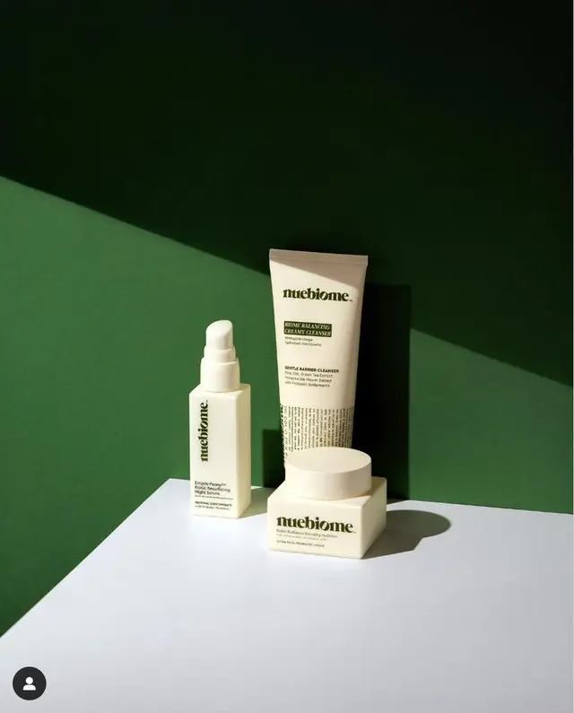 nuebiome skincare trio on dark green backdrop