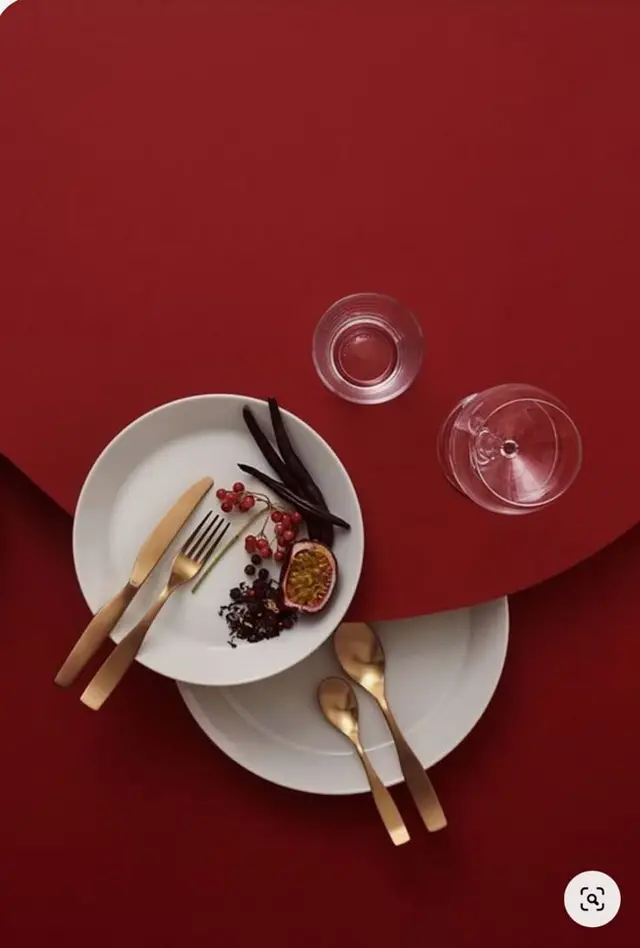 Burgundy tablescape — white plates with gold flatware and passionfruit