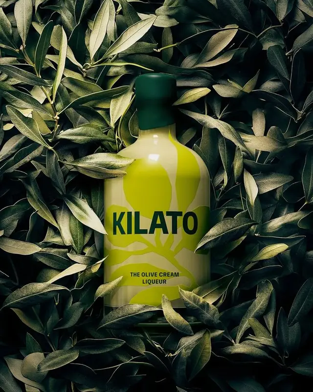 KILATO olive cream liqueur bottle surrounded by olive leaves