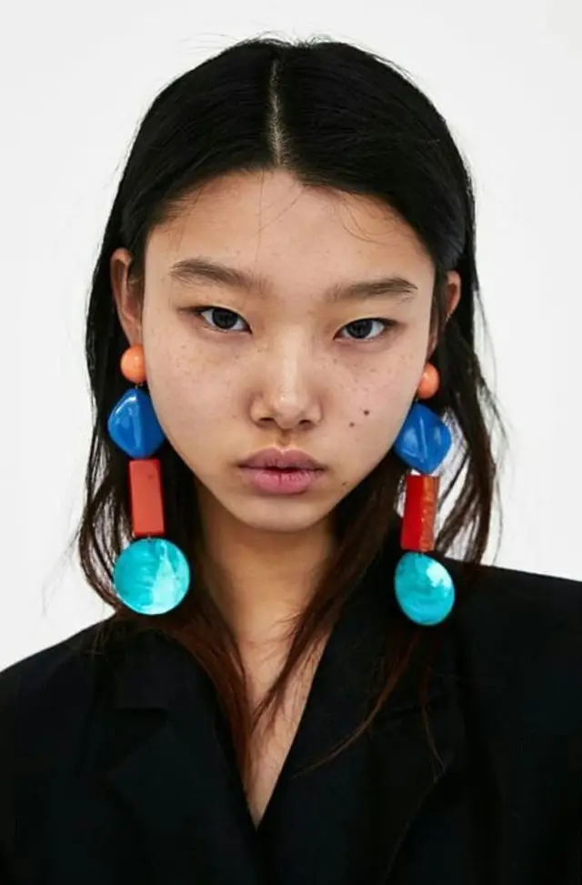 Oversized geometric acrylic drop earrings in turquoise, cobalt and red — studio portrait