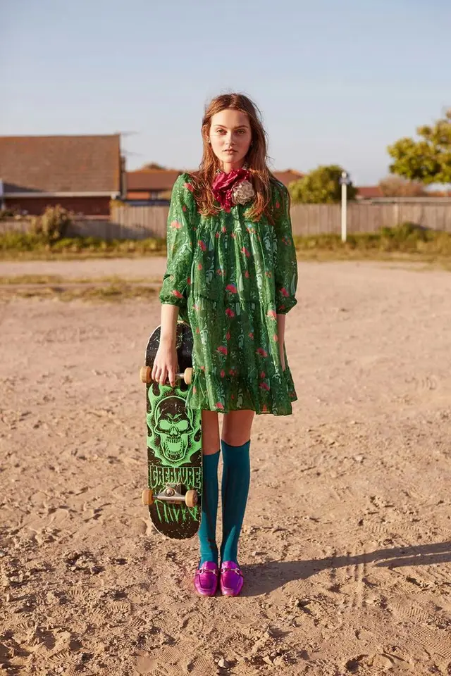 Green floral dress with Creature skateboard — editorial portrait