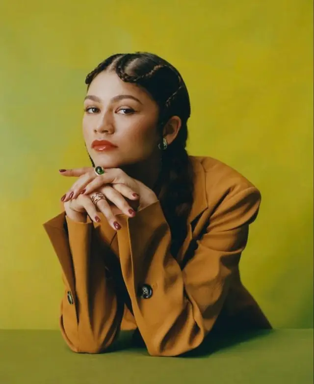 Studio portrait — woman in mustard blazer with braided finger waves and green ring