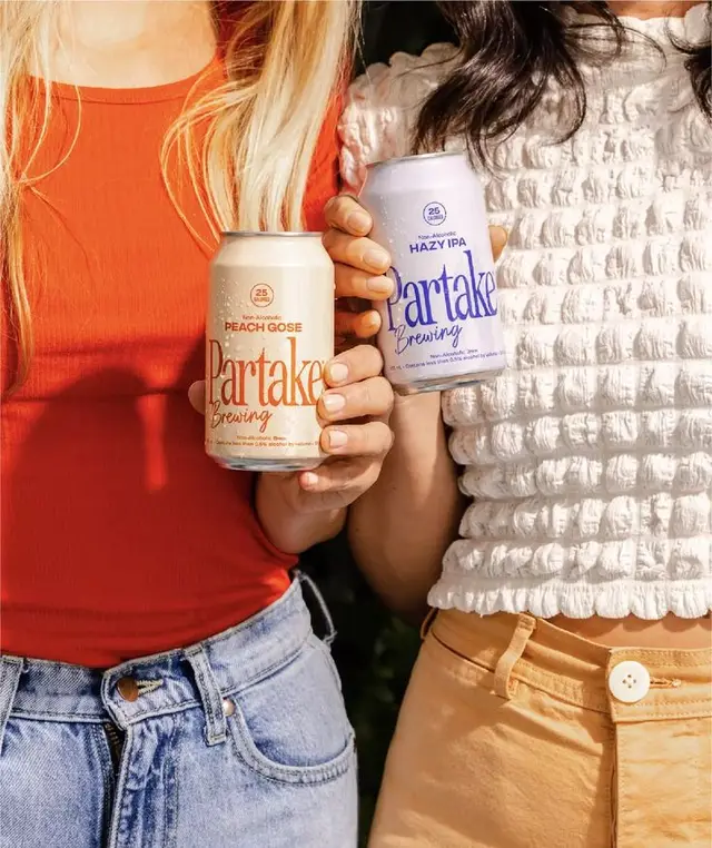 Partake Brewing cans — Peach Gose & Hazy IPA, lifestyle close-up