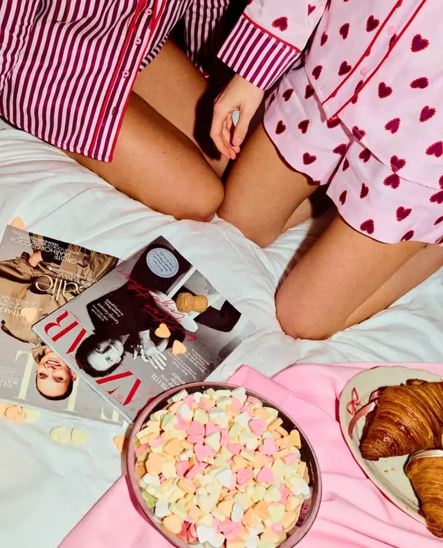 Breakfast-in-bed pajama party with pastel candy hearts and croissants