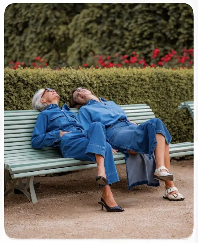Matching denim outfits on mint-green park bench