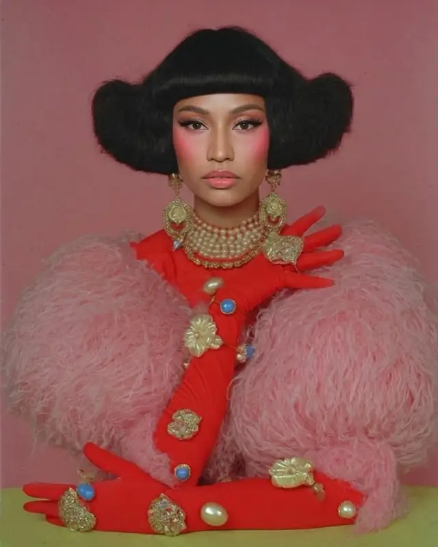 Studio fashion portrait — pink feather sleeves and red jeweled gloves