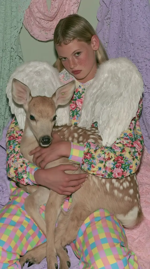 Pastel editorial: angel wings cradling a spotted fawn