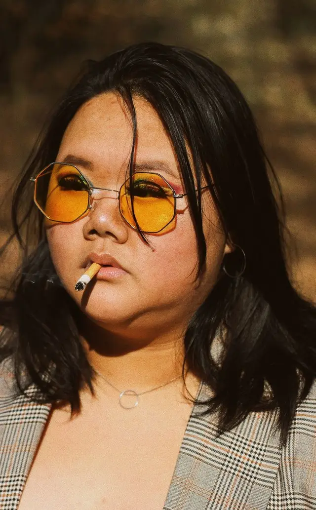 Close-up portrait with yellow hexagonal sunglasses and cigarette