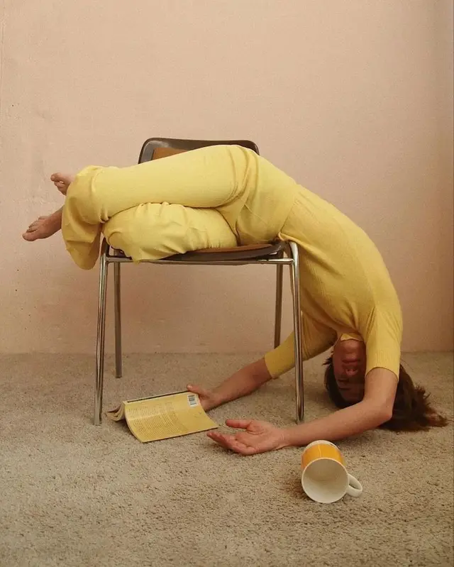 Person in mustard-yellow outfit draped over chair in pastel room