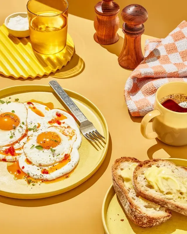 Buttered sourdough & sunny-side eggs — warm yellow breakfast flatlay
