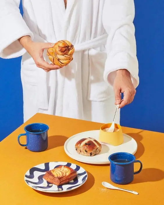 Breakfast styling with blue enamel mugs, pastries and yellow ramekin