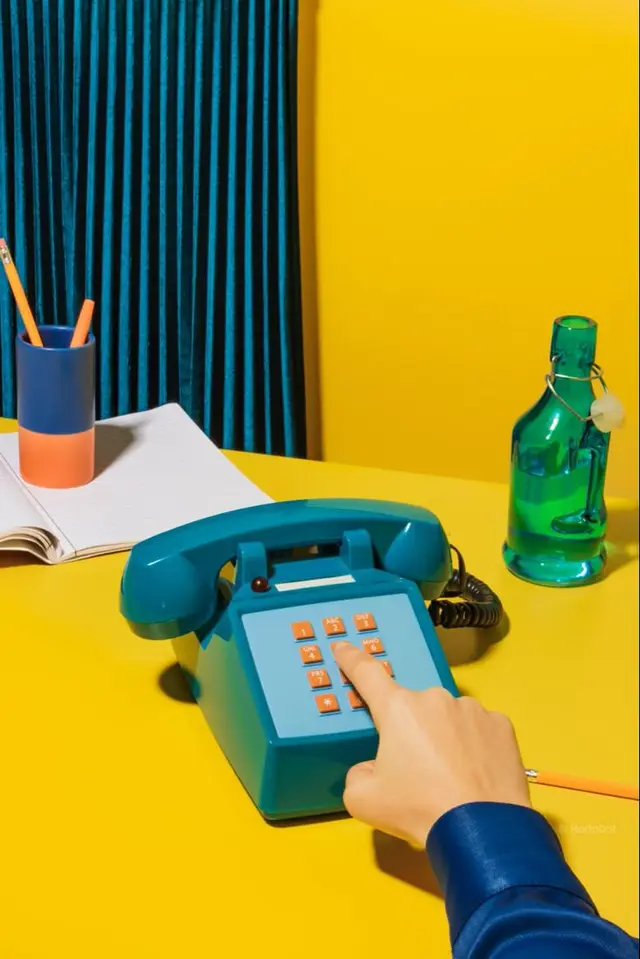 Teal Push-Button Phone on Yellow Table — Retro Color-Blocked Still Life