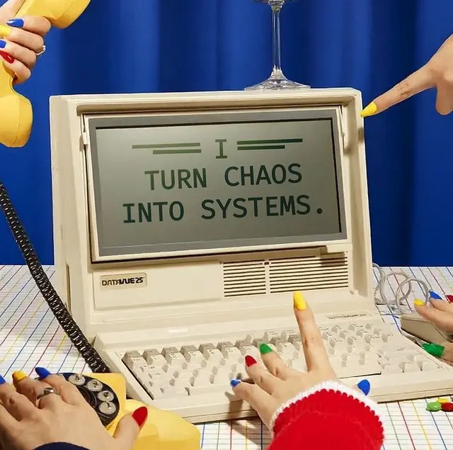 Vintage Datavue 25 computer with screen text “I TURN CHAOS INTO SYSTEMS.” and colorful man