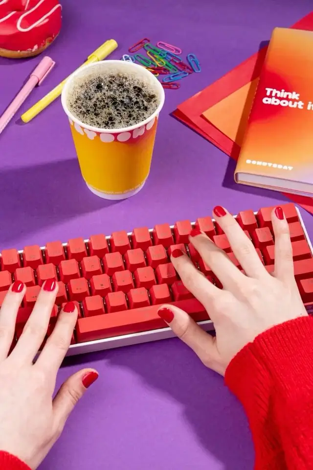 Colorful flat-lay desk: red keyboard, coffee cup, gradient notebook