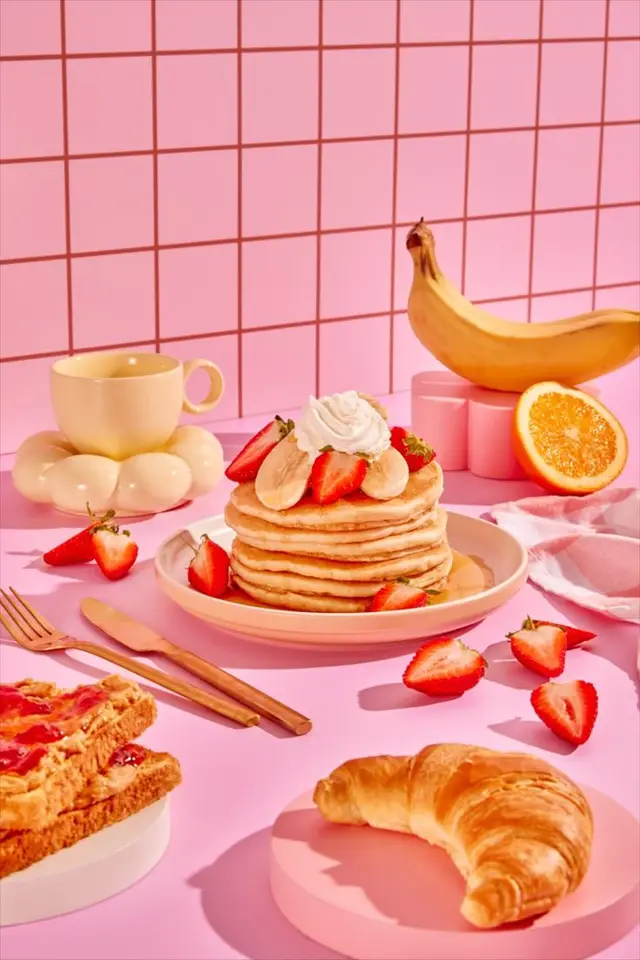 Pink pastel breakfast still life — pancakes with strawberries and croissant