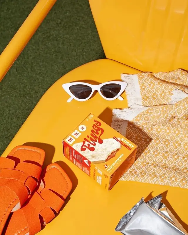 Yellow pool lounger still life with white cat-eye sunglasses and orange slides