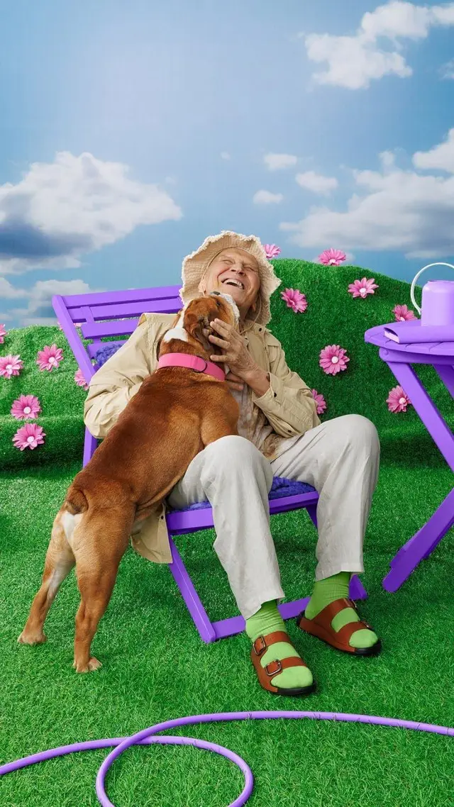Senior Laughing with Dog on Purple Garden Set