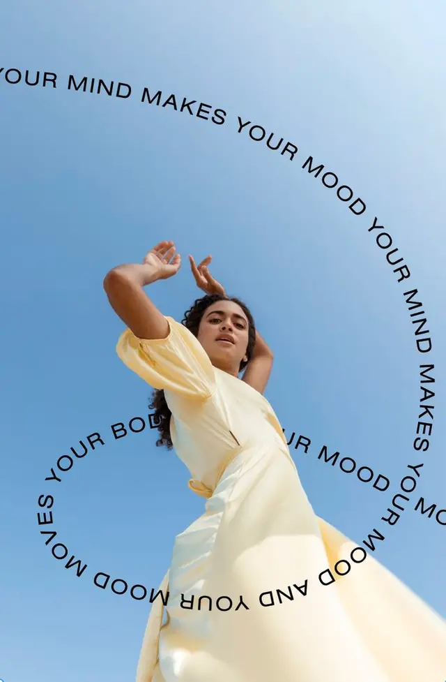 Low-angle editorial: pale yellow wrap dress with circular motivational text