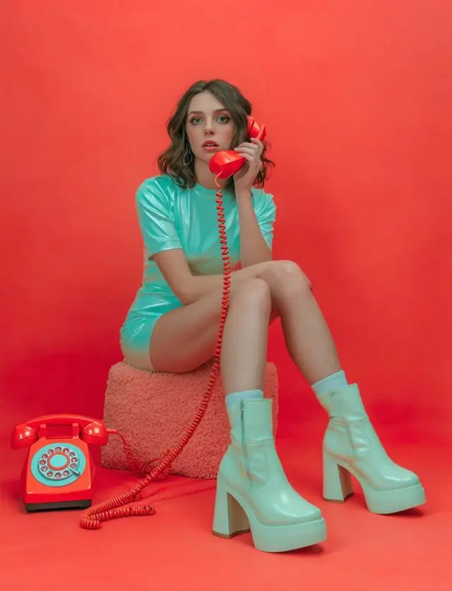 Mint vinyl mini dress and red rotary phone — retro fashion editorial