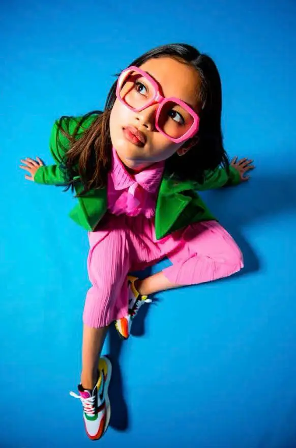 Editorial: child model in hot-pink pleated set, kelly green blazer and oversized pink eyeg