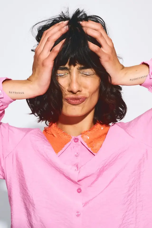 Studio portrait — woman in bubblegum pink shirt with orange sequin collar
