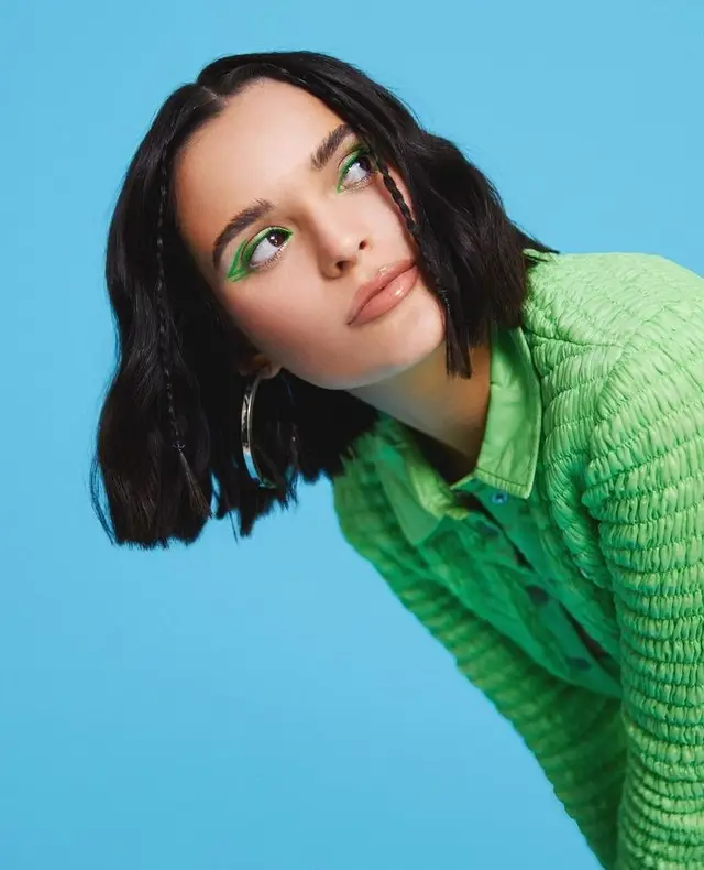 Graphic neon-green eyeliner and textured lime jacket — studio beauty portrait