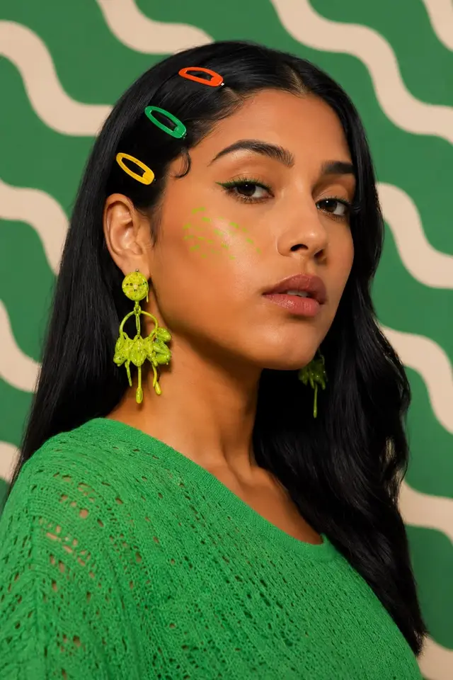 Green monochrome fashion portrait with neon resin earrings and colorful clips