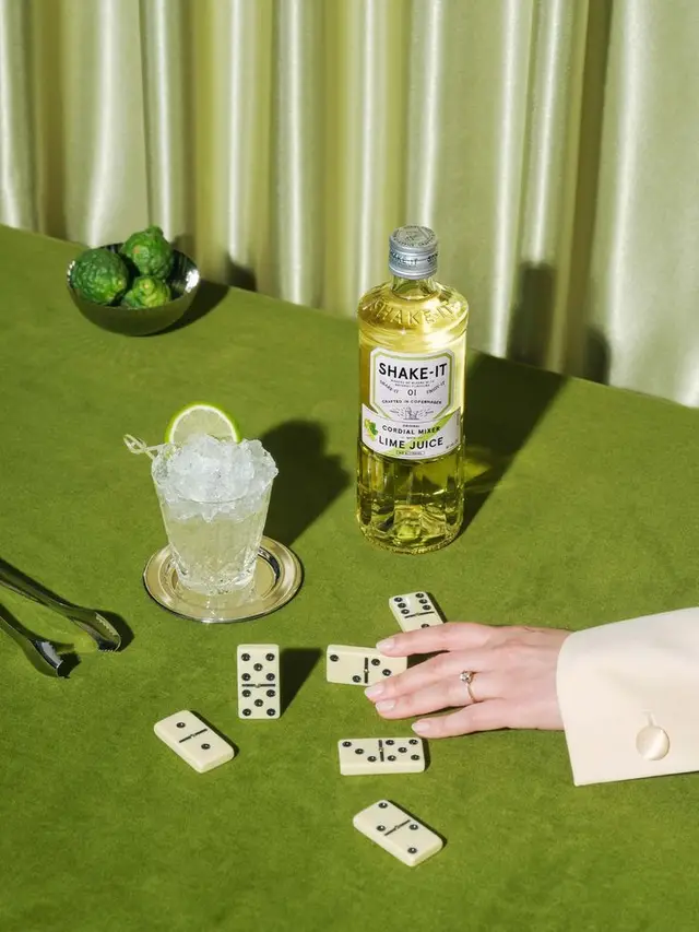 SHAKE-IT Lime Cordial on Green Velvet Table with Dominoes